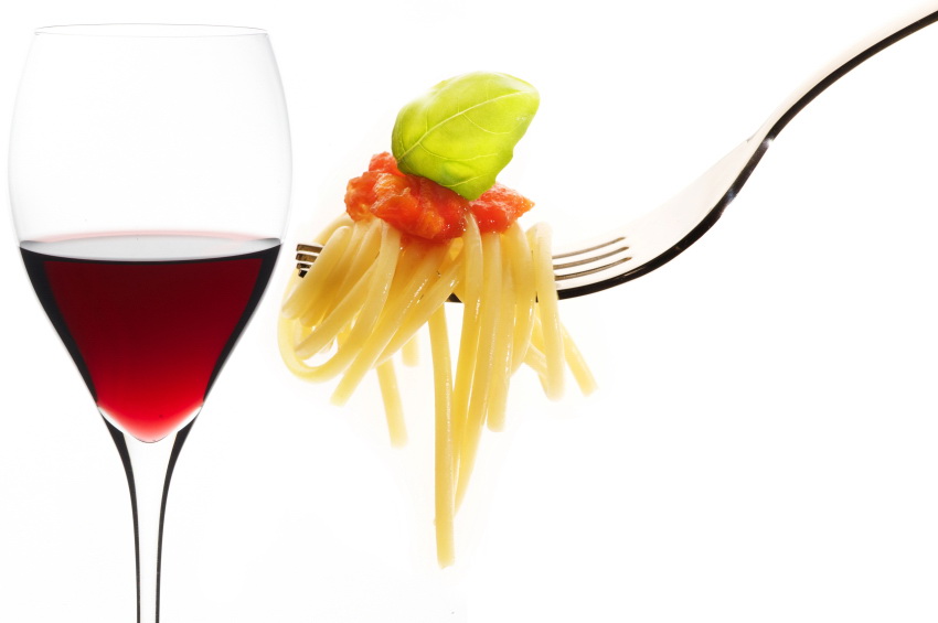 red wine glass and fork with spaghetti on white background