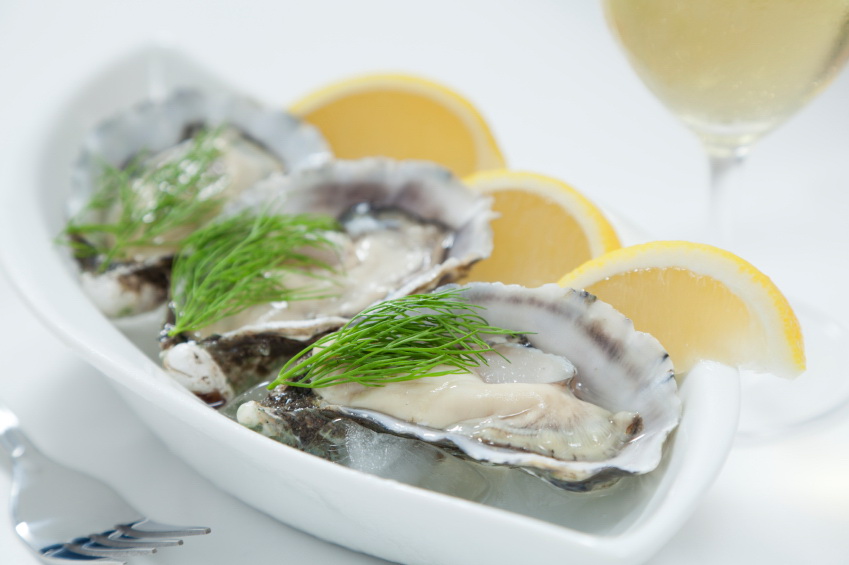 Fresh river oysters on ice with dill, lemon and wine
