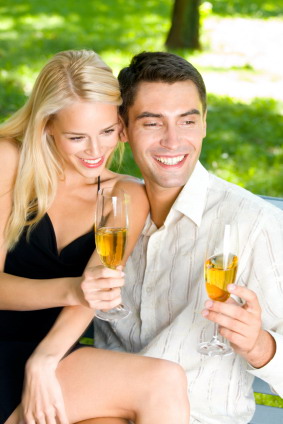 Young couple celebrating with champagne together, outdoors