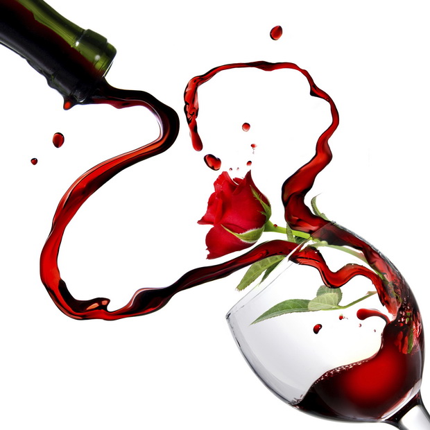 Heart from pouring red wine in goblet with red rose isolated on white