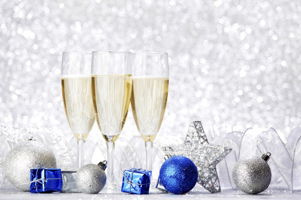 Glasses of champagne and decorative christmas balls on glitter background