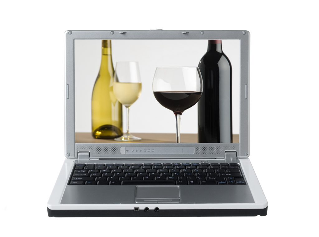 laptop computer with an image of wine bottles and wine glasses on the screen